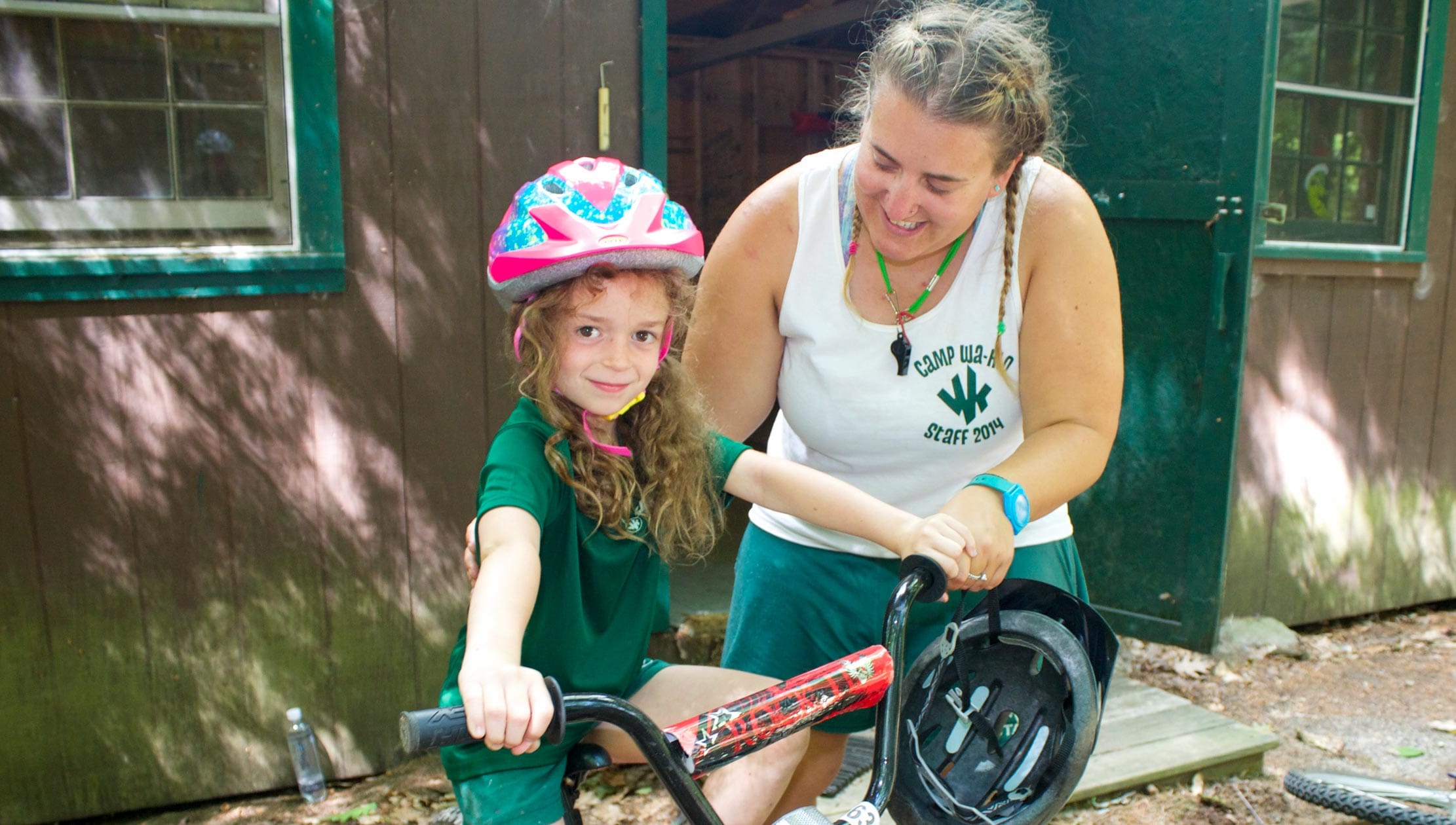 Camper learning how to ride a bike with staff