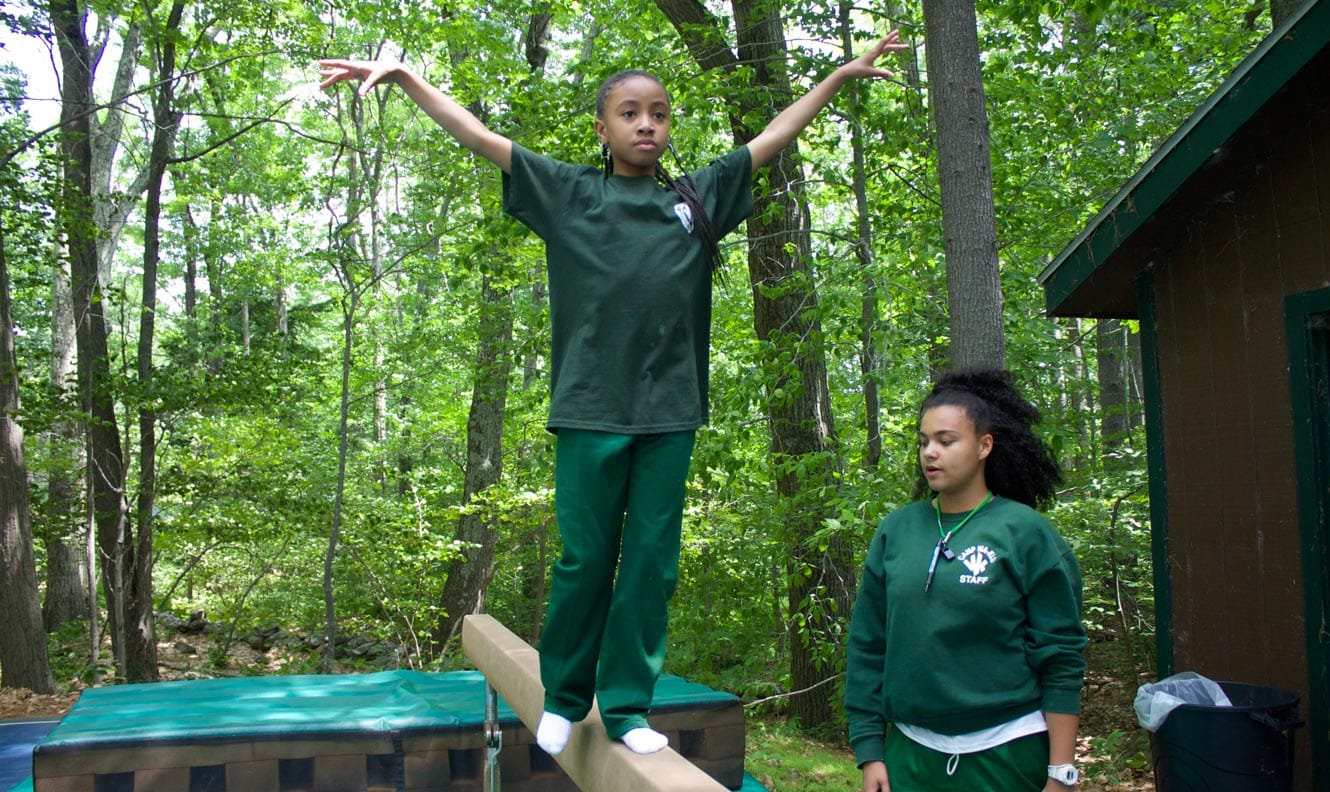 Staff helping camper at gymnastics