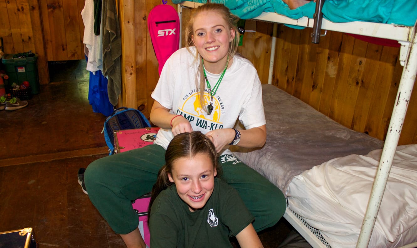 Staff doing camper's hair in bunk