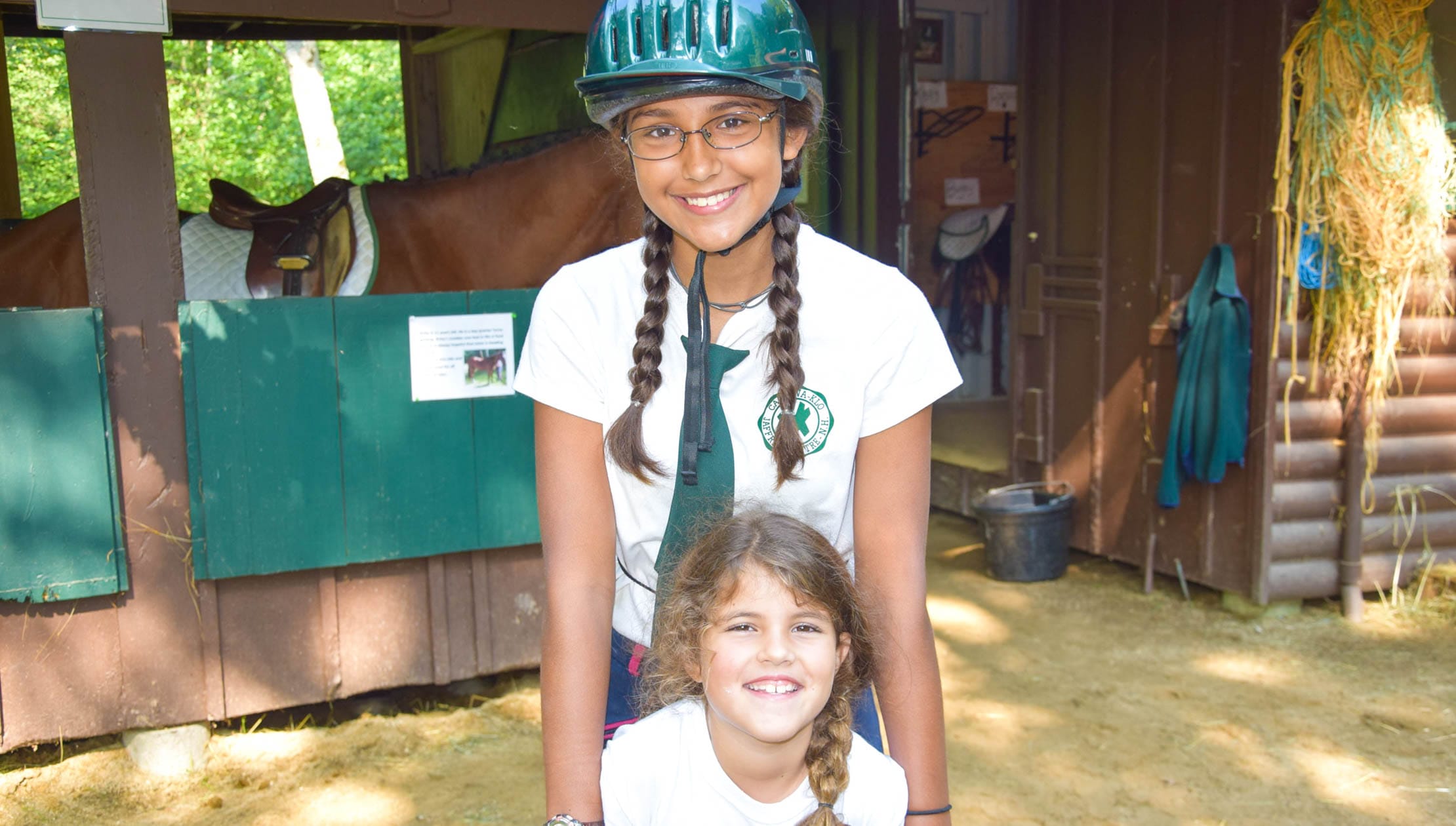 Staff and camper by horse stables