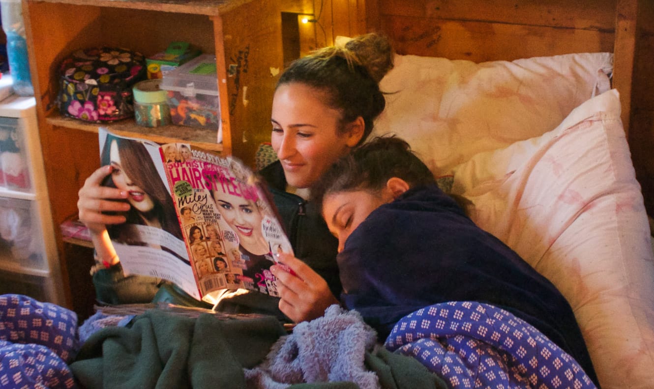 Staff reading while camper sleeps