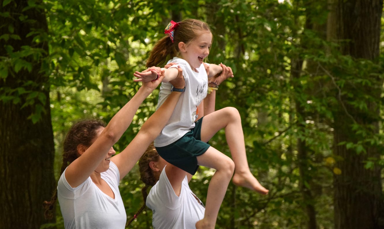 Staff lifting girl in air