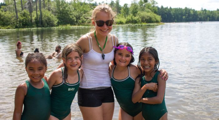 Staff and four campers by waterfront smiling