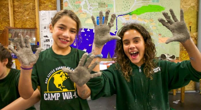 Two campers with clay on their hands