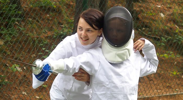 Fencing instructor teaching a camper