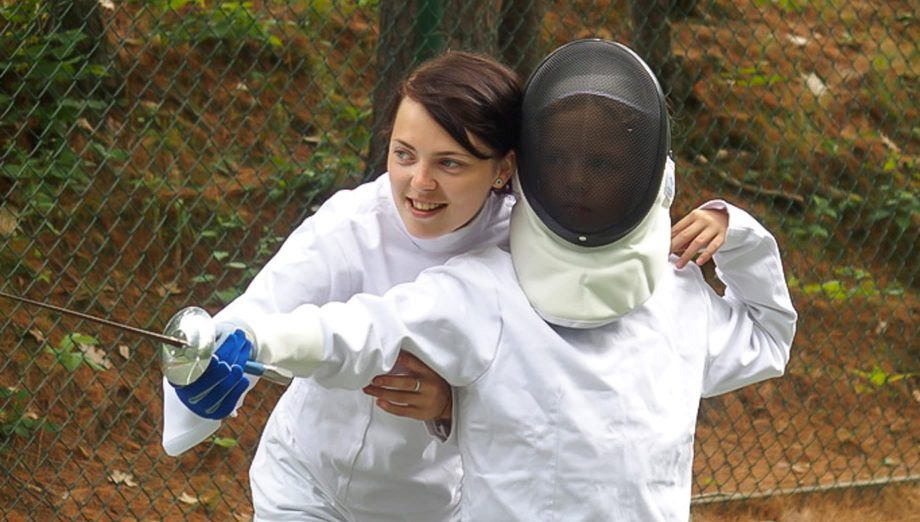 Fencing instructor teaching a camper