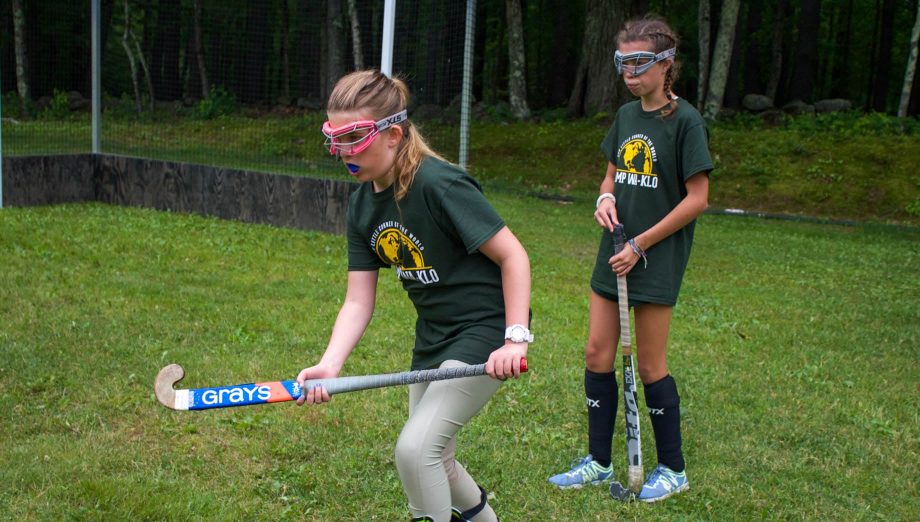 Campers playing field hockey