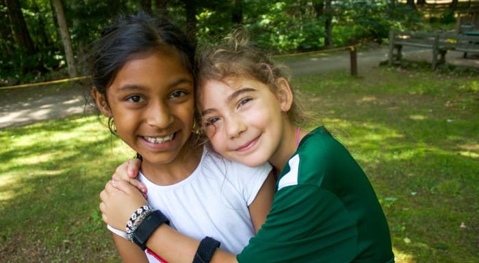 Two girls hugging and smiling