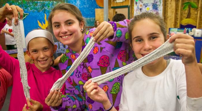 Girls stretching glitter putty in arts and crafts