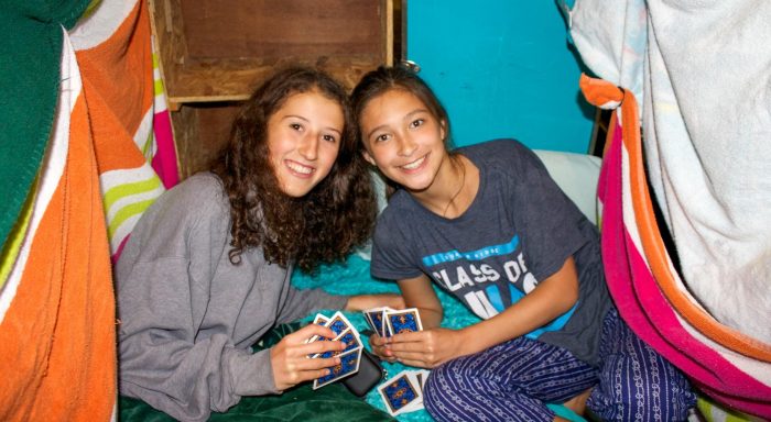 Two girls playing cards in their bunk