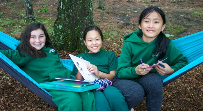 Three girls reading on a hammock