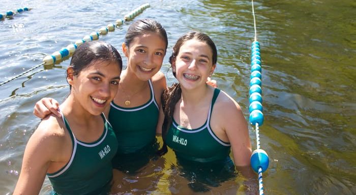 Three girls swimming in lake